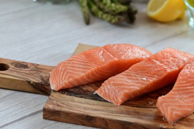 Yüksek kaliteli çiğ somon filetosu. Canlı turuncu bir tonu var. Açık arkaplanda güzelce yerleştirilmiş.