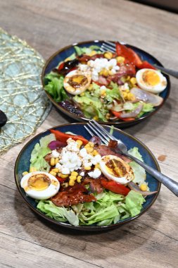 Gümüş bir karıştırma kasesinde Hollandaise sosu için yumurta hazırlama ve çırpma işlemi