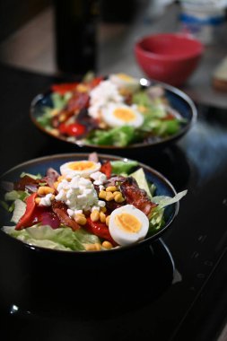 Taze sebzeli salata ve siyah tabakta meyve.