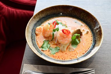 Baharatlı Tayland Tom Yum Goong Çorbası, karides, erişte ve otlu.