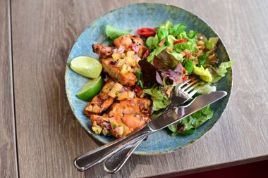 Sebzeli tavuk göğsü ve tabakta otlar..