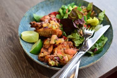 Tahta tabakta salata ile kızarmış tavuk kanadı.