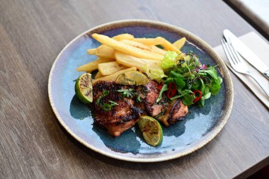 Restoranda servis edilen ızgara tavuk göğsü ve sebze.