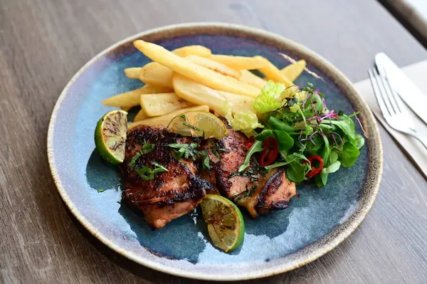 Kızarmış tavuk, patates kızartması ve salata.