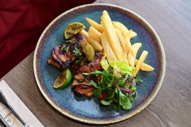 Tahta tabakta sebzeli ve baharatlı ızgara tavuk..