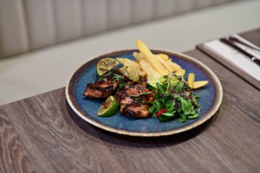 Restorandaki masada ızgara biftek ve sebze.