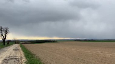 Buğday tarlasında bir fırtına, Çek kırsalında kara bulutlu dramatik bahar gökyüzü