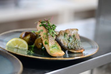 Tabağında sebze olan ızgara alabalık.