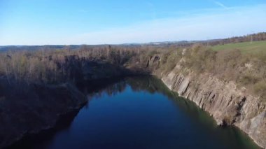  Çek Cumhuriyeti 'nin Kuzey Moravya şehrinde bulunan taşlı taş ocağının insansız hava aracı görüntüleri. Sahne nefes kesici ve güneşli gökyüzünün altında manzarayı yakalar. Kristal berraklığında mavi göl.