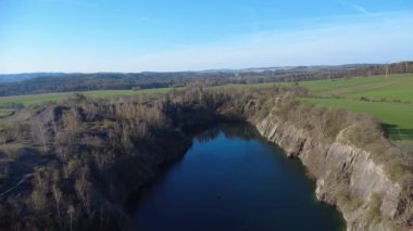 Çek Cumhuriyeti 'nin Kuzey Moravya şehrinde bulunan taşlı taş ocağının insansız hava aracı görüntüleri. Sahne, berrak ve güneşli gökyüzünün altındaki çarpıcı bahar manzarasını yakalar..
