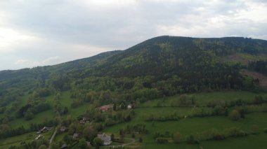 Çek Cumhuriyeti 'nin Hanuovice yakınlarındaki Vojtkov köyünün akşam manzarası. Ormanlar, yuvarlanan tepeler ve yumuşak akşam ışığında manzaralı kırsal manzarayla çevrili geleneksel bir kırsal bölge.