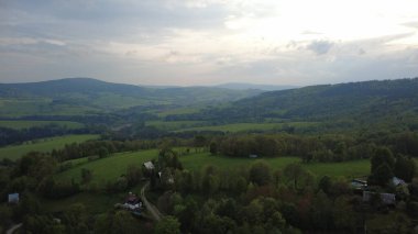Çek Cumhuriyeti 'nin Hanuovice yakınlarındaki Vojtkov köyünün akşam manzarası. Ormanlar, yuvarlanan tepeler ve yumuşak akşam ışığında manzaralı kırsal manzarayla çevrili geleneksel bir kırsal bölge.