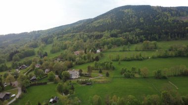 Çek Cumhuriyeti 'nin Hanuovice yakınlarındaki Vojtkov köyünün akşam manzarası. Ormanlar, yuvarlanan tepeler ve yumuşak akşam ışığında manzaralı kırsal manzarayla çevrili geleneksel bir kırsal bölge.