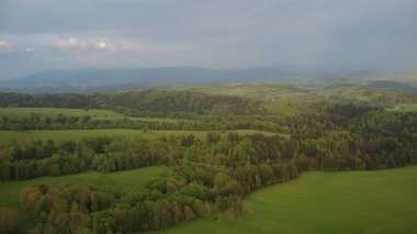 Çek Cumhuriyeti 'nin Hanuovice yakınlarındaki Vojtkov köyünün akşam manzarası. Ormanlar, yuvarlanan tepeler ve yumuşak akşam ışığında manzaralı kırsal manzarayla çevrili geleneksel bir kırsal bölge.