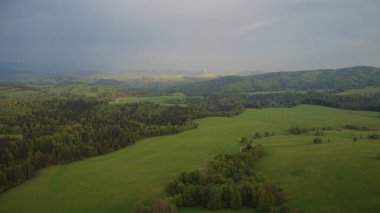 Çek Cumhuriyeti 'nin Hanuovice yakınlarındaki Vojtkov köyünün akşam manzarası. Ormanlar, yuvarlanan tepeler ve yumuşak akşam ışığında manzaralı kırsal manzarayla çevrili geleneksel bir kırsal bölge.