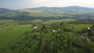 Çek Cumhuriyeti 'nin Hanuovice yakınlarındaki Vojtkov köyünün akşam manzarası. Ormanlar, yuvarlanan tepeler ve yumuşak akşam ışığında manzaralı kırsal manzarayla çevrili geleneksel bir kırsal bölge.