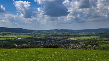 Çek Cumhuriyeti, Orlick Hory 'da nefes kesen bahar manzarası. Panoramik bir manzara, yemyeşil tepeleri, açık mavi gökyüzünü ve Çek kırsalının güzelliğini gözler önüne seriyor..