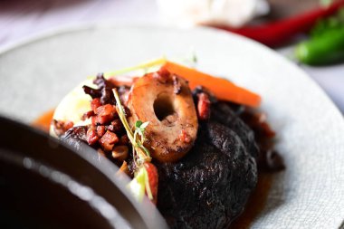 Sebzeli biftek ve tabakta otlar.