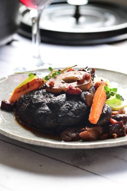 Siyah tabakta ızgara biftek, beyaz arka planda.