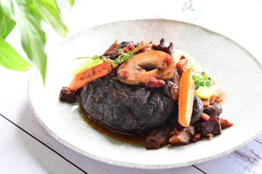 Kızarmış biftek ve beyaz tabakta sebze..