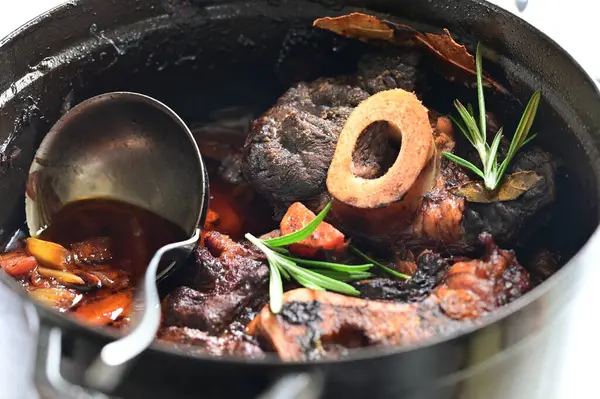 Biberiyeli biftek ve tavada baharat, beyaz masada, yakın plan.