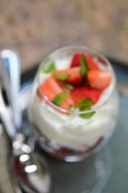 Çilekli bir bardak taze yoğurdun yakın plan çekimi.