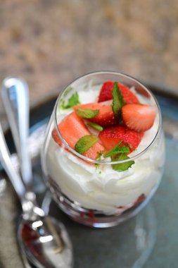Çilekli ve vanilyalı tatlı cam masada.