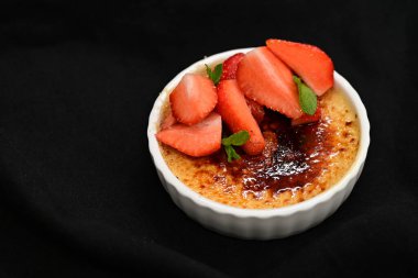 Siyah arka planda çilekli lezzetli tatlı.