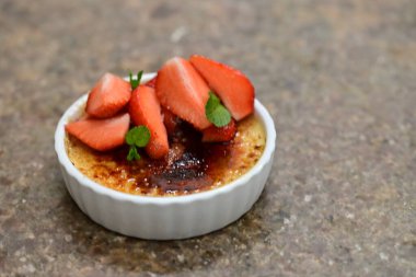 Krem şanti ve nane yaprağıyla çilekli tatlı.