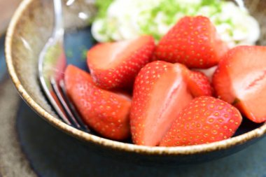 Ahşap arka planda bir kasede çilek