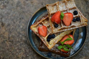 Tabağında böğürtlen olan waffle.