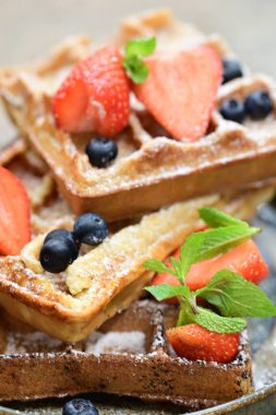 Renkli çan biberlerinin üst görüntüsü. İçi öğütülmüş et, pilav ve karışık sebzelerle doldurulmuş. Seramik bir fırın kabına dizilmiş.. 