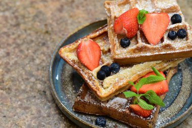 Renkli çan biberlerinin üst görüntüsü. İçi öğütülmüş et, pilav ve karışık sebzelerle doldurulmuş. Seramik bir fırın kabına dizilmiş.. 