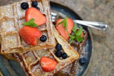 Çilekli waffle ve tabakta nane.