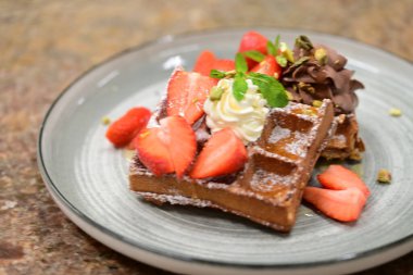 Bir parça dondurmanın yakın plan fotoğrafı. Çilekli dondurma ve tabakta çikolata.