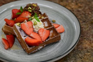 Kremalı, çilekli ve naneli çikolatalı waffle.