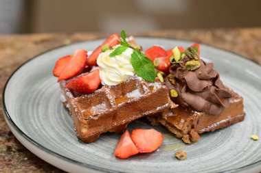 Çilekli ve kremalı bir parça çikolatalı pasta.