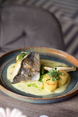 Kızarmış balık, patates, bezelye ve sarımsak sosu..