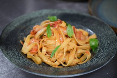 Tabağında deniz ürünleri olan makarna.