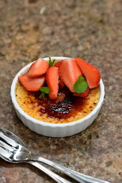 Taze çilek ve nane yapraklı lezzetli bir tatlı.