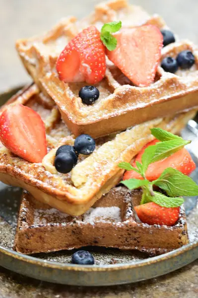 Renkli çan biberlerinin üst görüntüsü. İçi öğütülmüş et, pilav ve karışık sebzelerle doldurulmuş. Seramik bir fırın kabına dizilmiş.. 