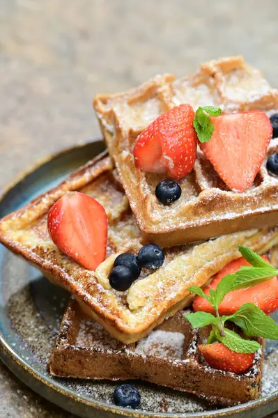 Renkli çan biberlerinin üst görüntüsü. İçi öğütülmüş et, pilav ve karışık sebzelerle doldurulmuş. Seramik bir fırın kabına dizilmiş.. 