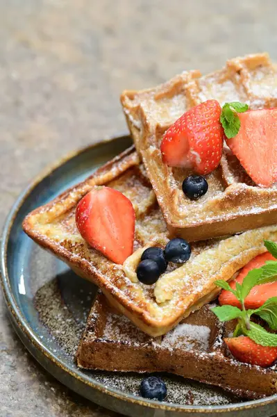 Renkli çan biberlerinin üst görüntüsü. İçi öğütülmüş et, pilav ve karışık sebzelerle doldurulmuş. Seramik bir fırın kabına dizilmiş.. 