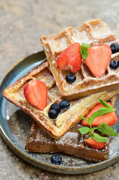 Renkli çan biberlerinin üst görüntüsü. İçi öğütülmüş et, pilav ve karışık sebzelerle doldurulmuş. Seramik bir fırın kabına dizilmiş.. 