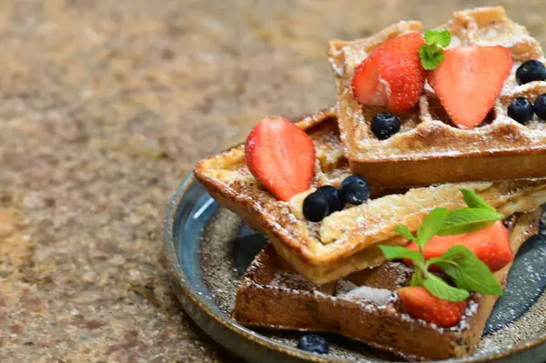 Renkli çan biberlerinin üst görüntüsü. İçi öğütülmüş et, pilav ve karışık sebzelerle doldurulmuş. Seramik bir fırın kabına dizilmiş.. 