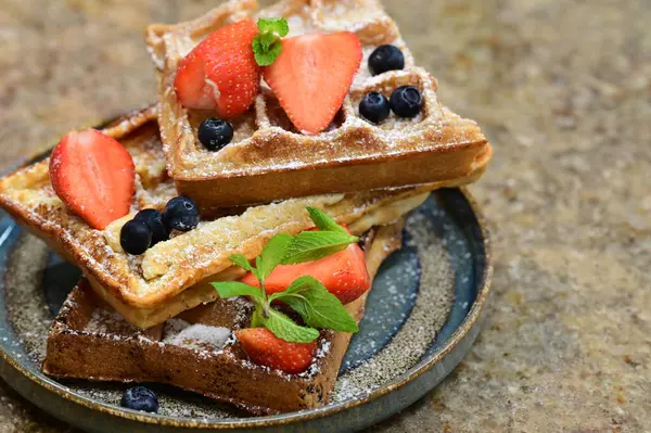 Renkli çan biberlerinin üst görüntüsü. İçi öğütülmüş et, pilav ve karışık sebzelerle doldurulmuş. Seramik bir fırın kabına dizilmiş.. 