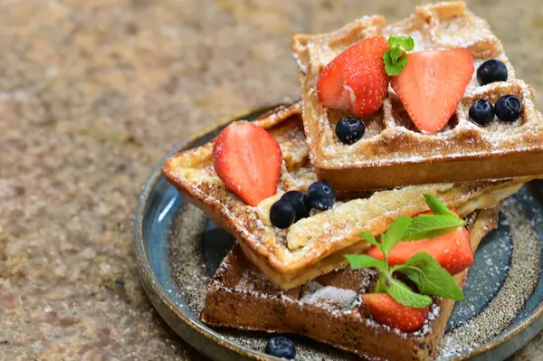 Renkli çan biberlerinin üst görüntüsü. İçi öğütülmüş et, pilav ve karışık sebzelerle doldurulmuş. Seramik bir fırın kabına dizilmiş.. 