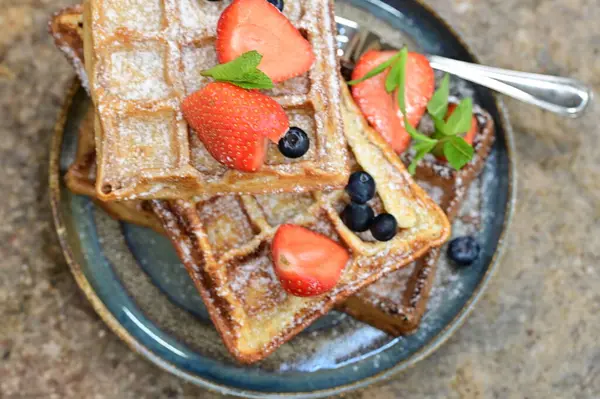 Çikolatalı lezzetli waffle 'lar, taze çilekler.