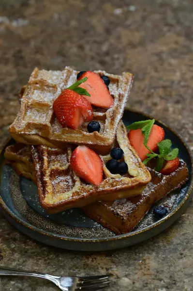 Siyah tabakta yaban mersinli ve çilekli waffle..