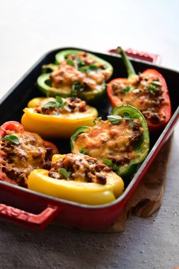 Ahşap masada siyah tabakta biber ve peynirli ızgara domates..